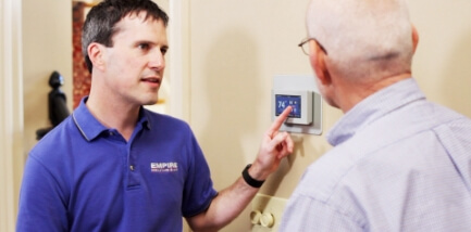 Technician demonstrating a thermostat.