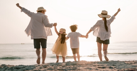 Family walking toward a sunset at the beach.