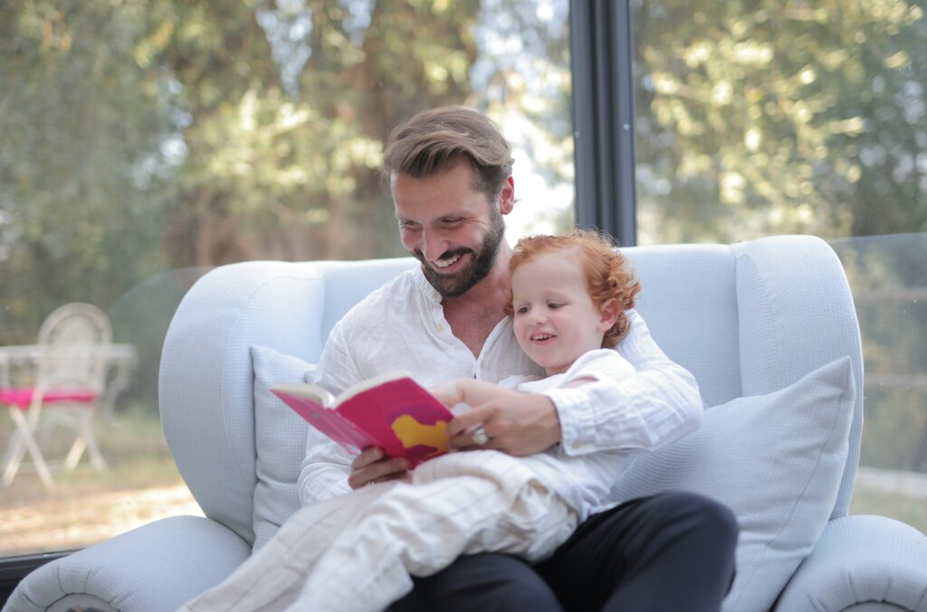 man is reading to his child in a comfortable home