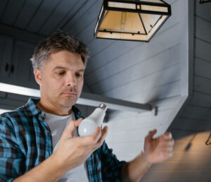man changes lightbulb using LED bulb