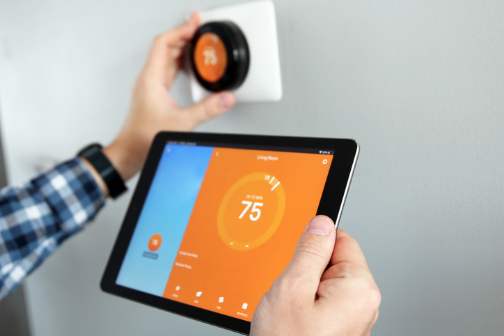 man adjusting smart thermostat