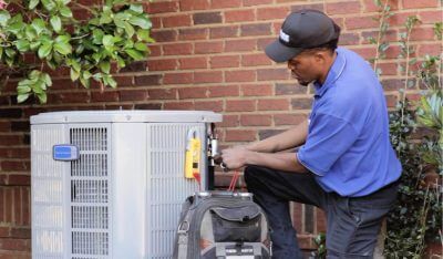 Empire HVAC technician working on an outdoor AC unit.