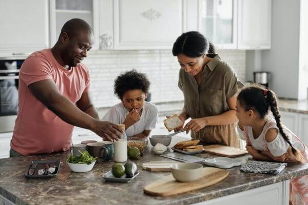 A happy family preparing a meal in a clean, bright kitchen.