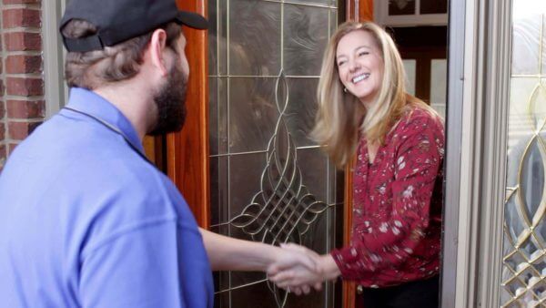 Customer greets the Empire HVAC technician at the front door with a smile and a hand-shake.
