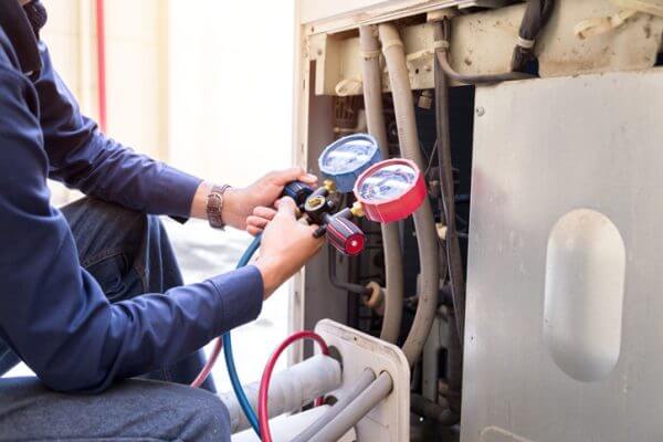 HVAC technician testing central air conditioning units