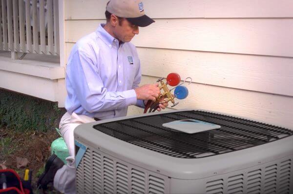 Empire HVAC tech performs a routine AC maintenance check.