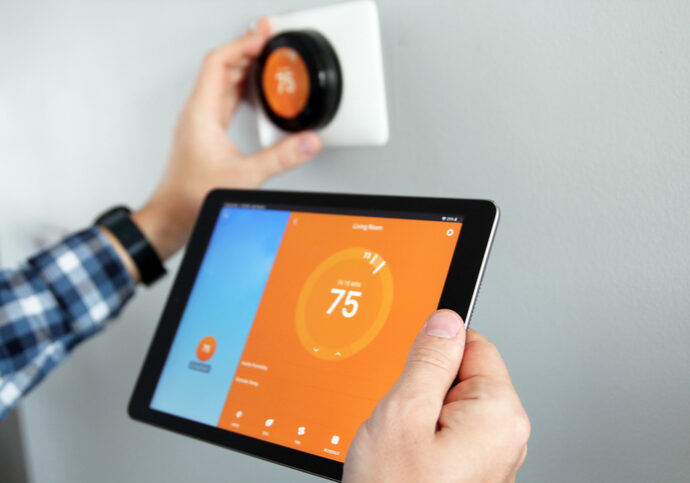 man adjusting smart thermostat