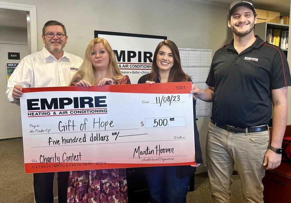 Empire staff with large check for Gift of Hope donation
