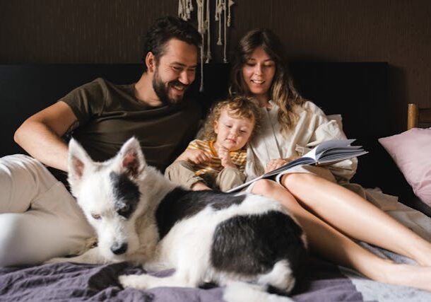 family with dog snuggles in comfortable bed