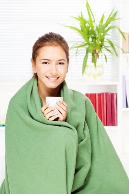 woman wrapped in a blanket and smiling